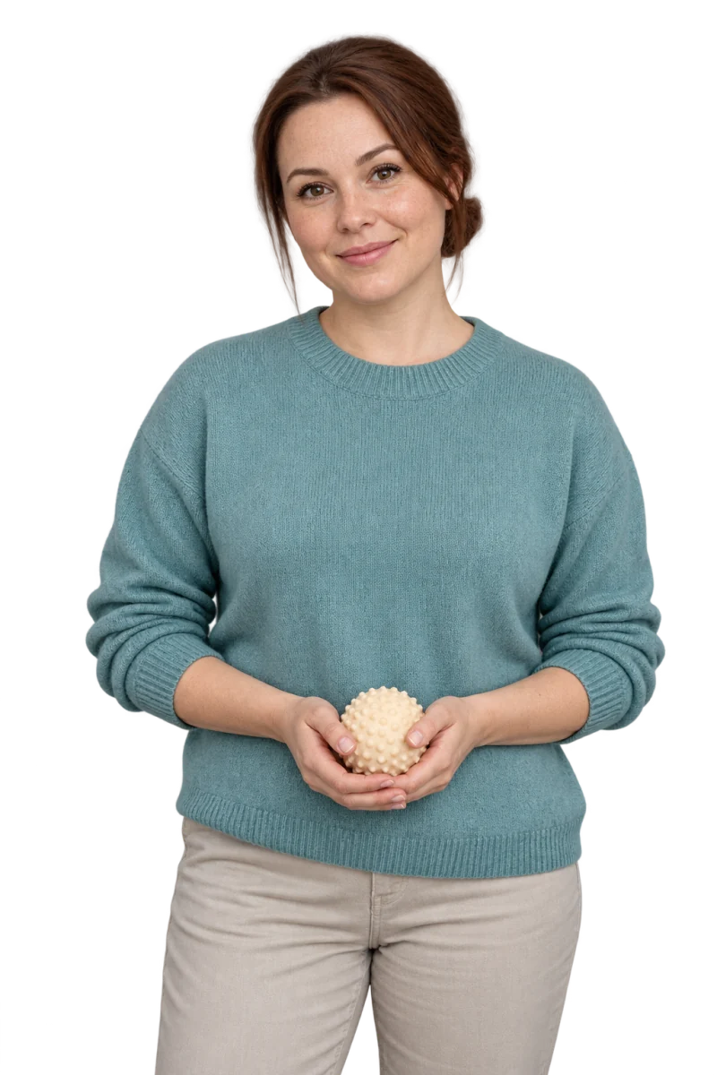 Fotorealistyczna ilustracja terapeutki integracji sensorycznej w turkusowym swetrze, z małą piłką sensoryczną.