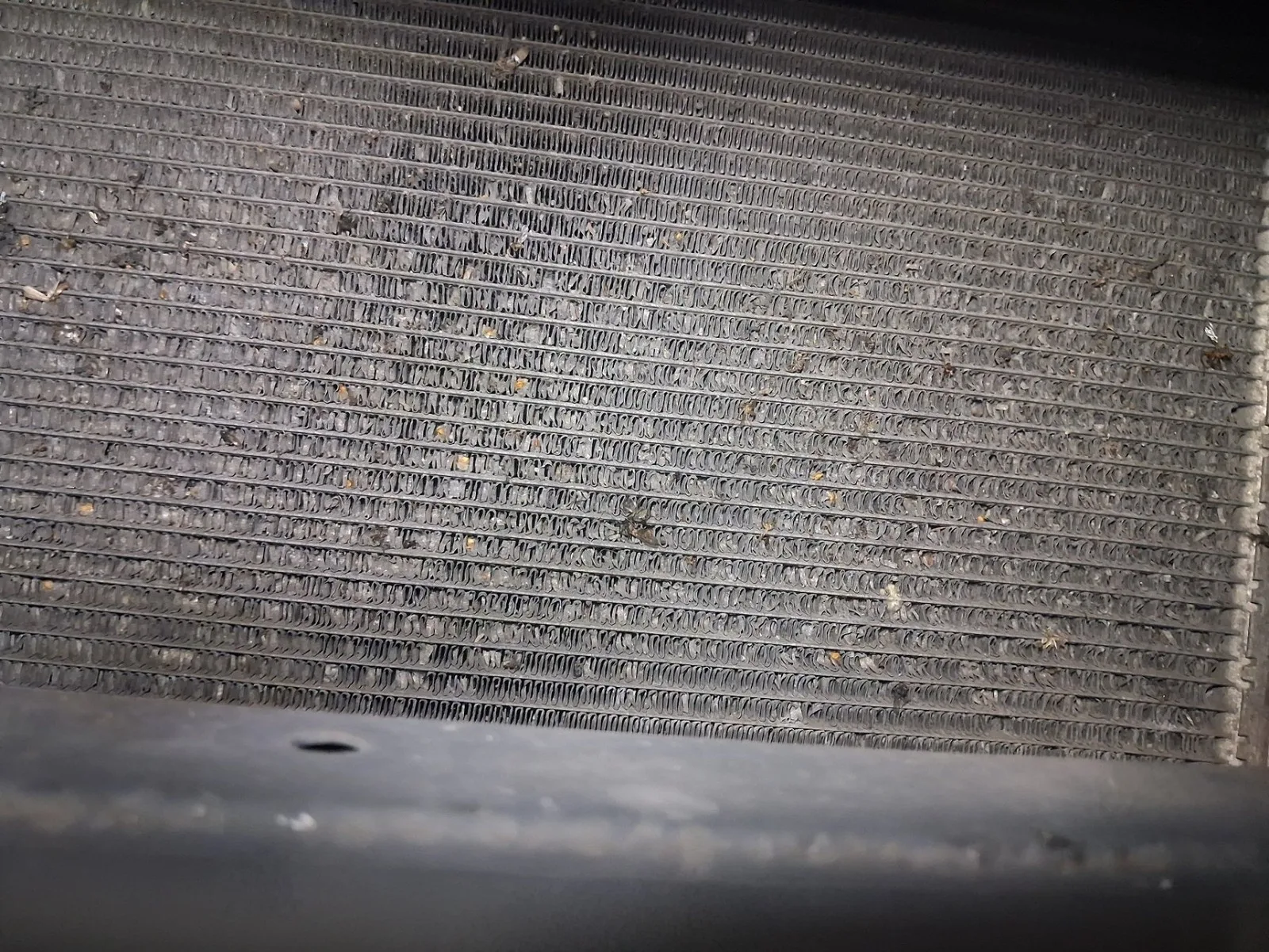 Widoczny pokruszony rdzeń skraplacza klimatyzacji przed wymianą.